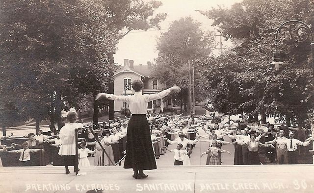 Woman leading rows of guests in exercises outside of the Battle Creek Sanitarium